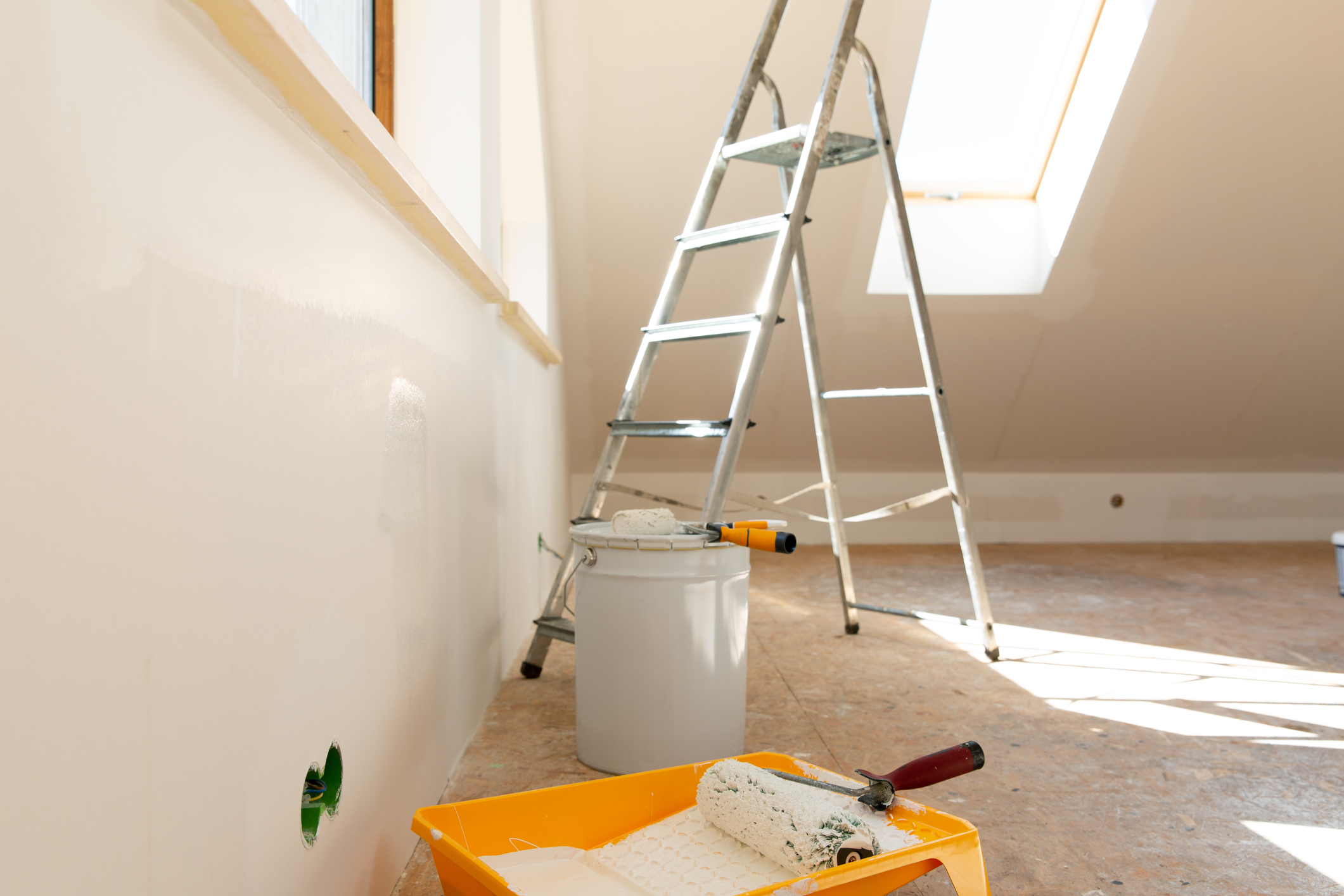 home improvement. painting tools roller, paint bucket and paintbrush in a natural light.